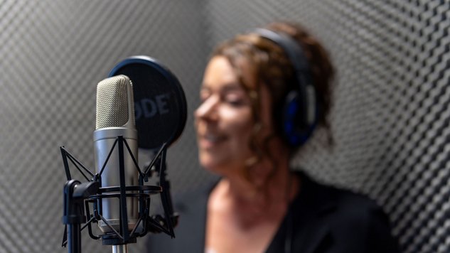 Studio1® Sprecherin in der Sprecherkabine am Mikrofon
